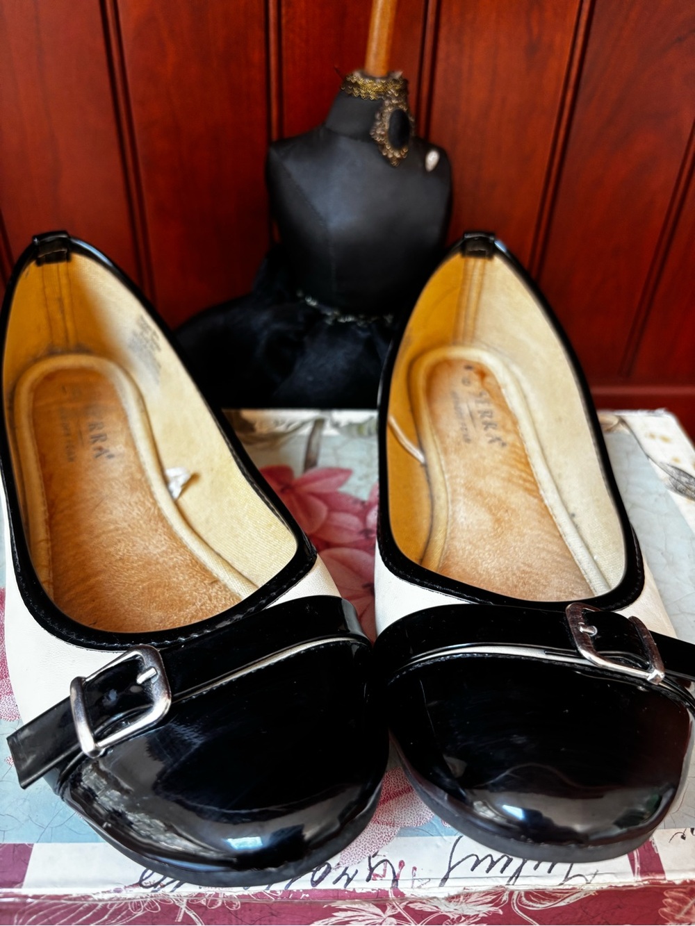 Serra black and white cap-toe ballet flats featuring a decorative buckle